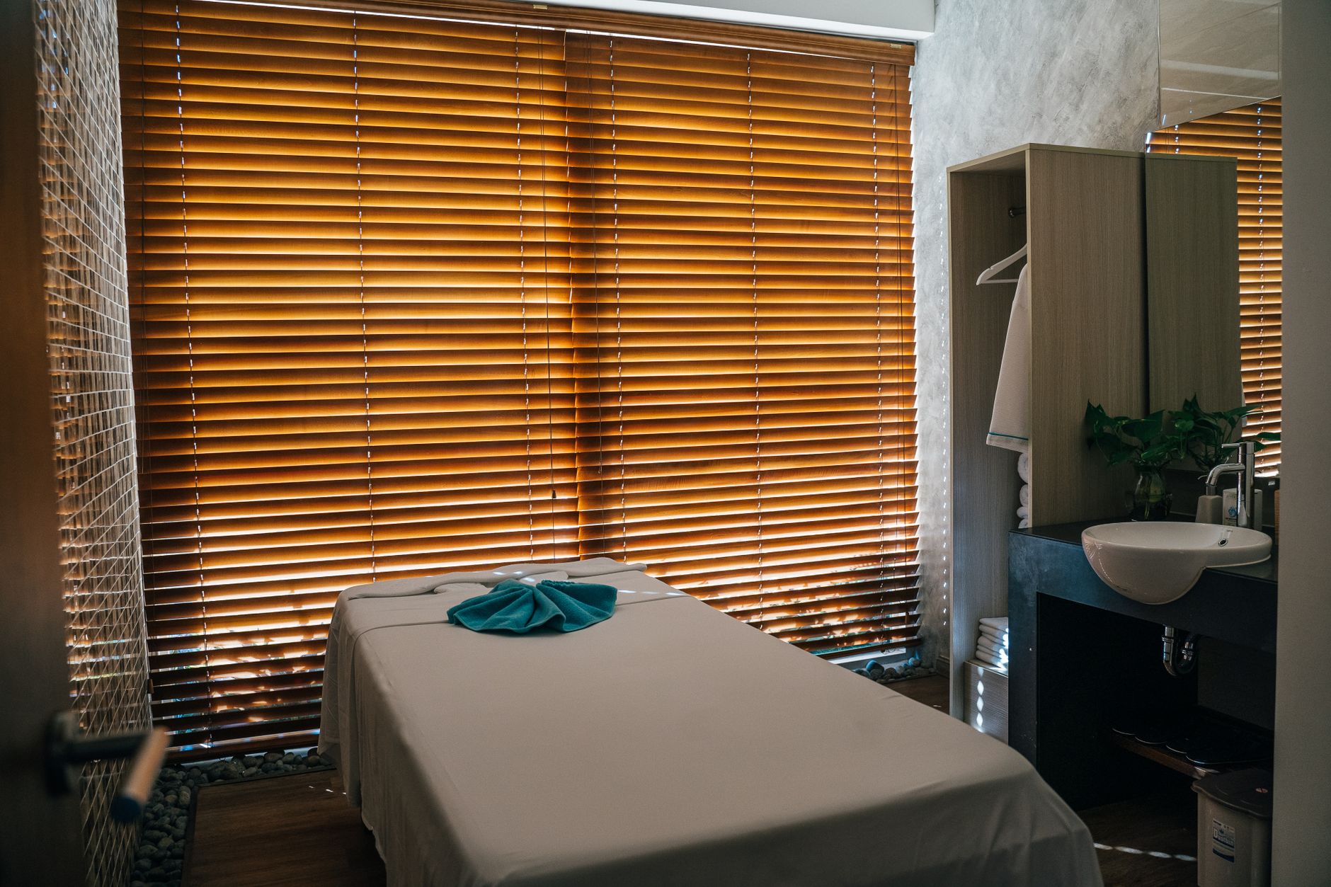 Massage table made up with fresh linens and a folded towel in a calm, warmly lit room
